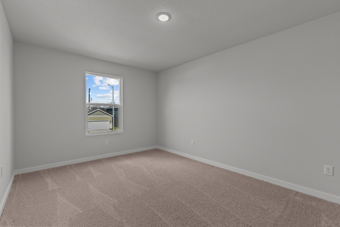 A room with a window and a carpet.