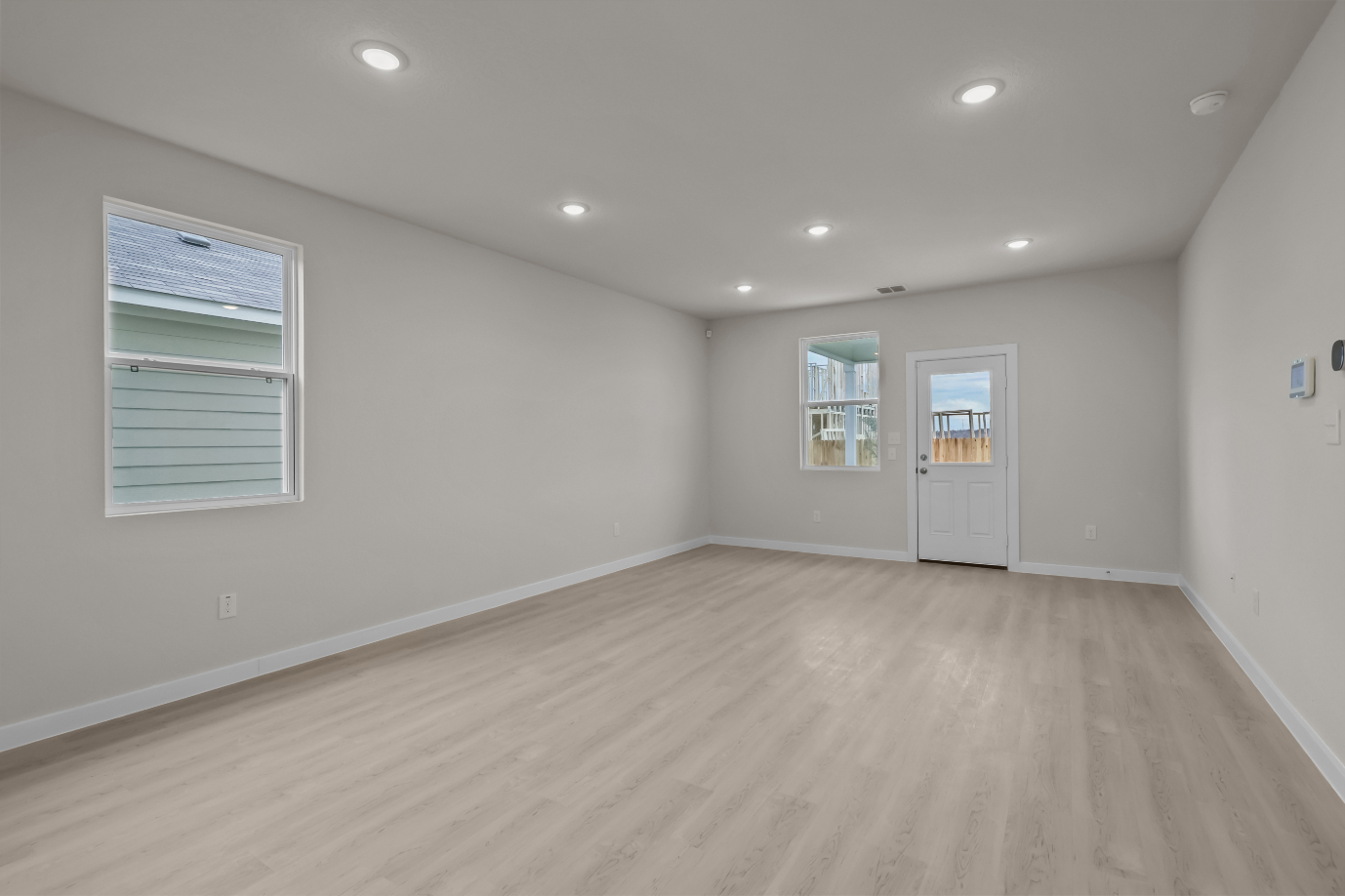 A room with a wood floor and white walls.