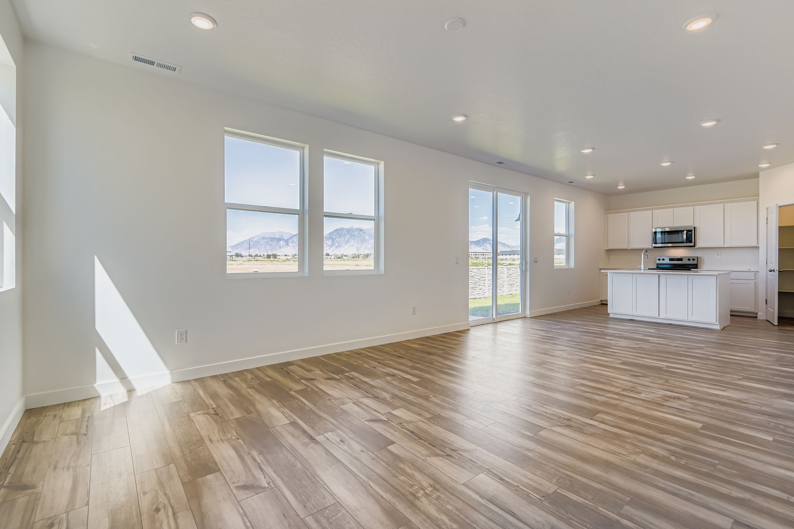 A large empty room with a wood floor and a wood floor.
