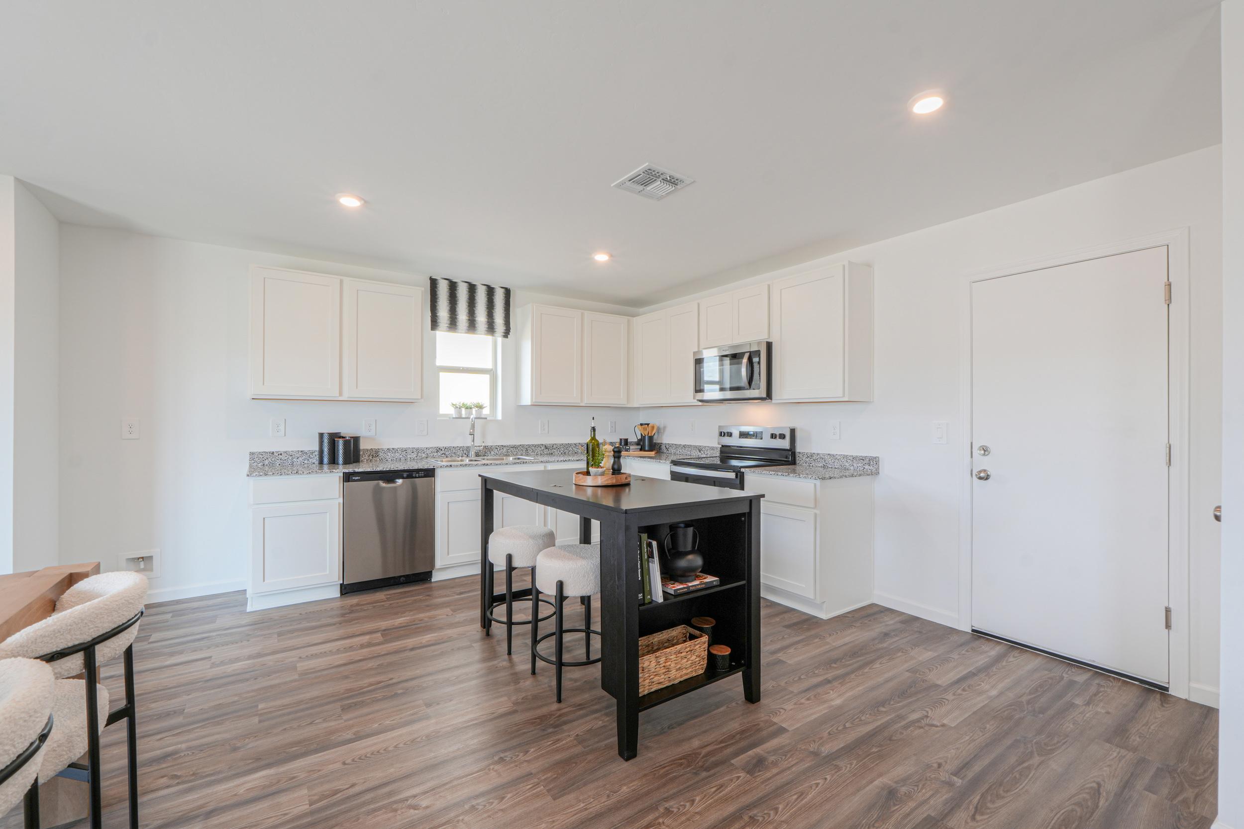 A kitchen with white cabinets.