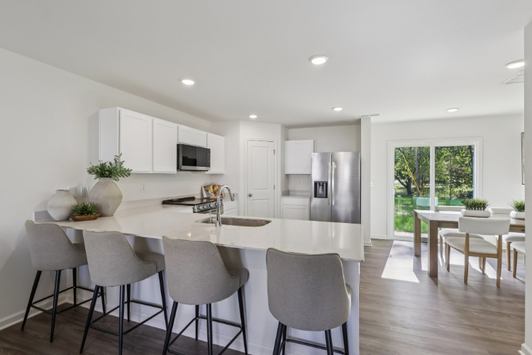 A kitchen with a dining table and chairs.