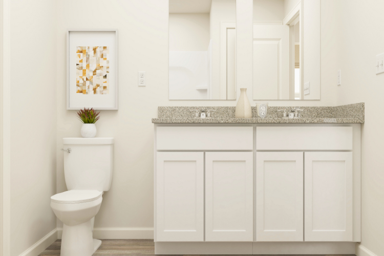 A bathroom with white cabinets.