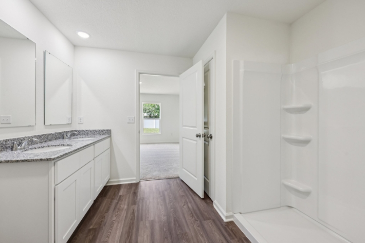 A bathroom with white cabinets.