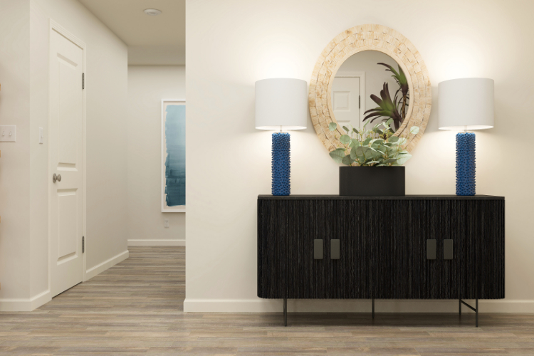 A room with a mirror and a vase with flowers on it.