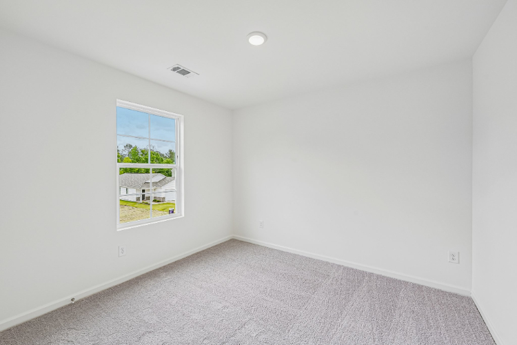 A room with a window and a carpet.