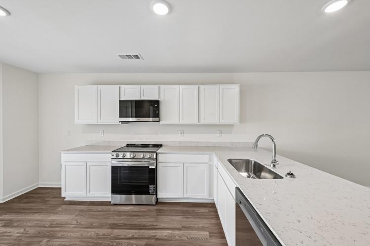 A kitchen with white cabinets.