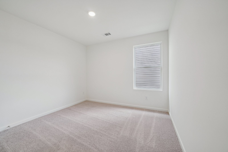 A room with a carpet and a door.