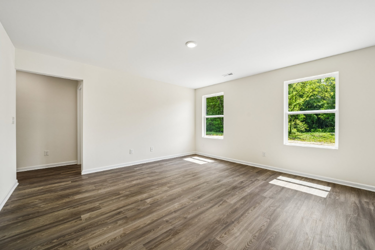 A room with a wood floor and a wood floor with a window.