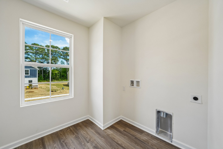A room with a window and a wood floor.