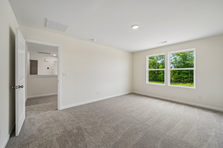 A room with a carpet and a window.