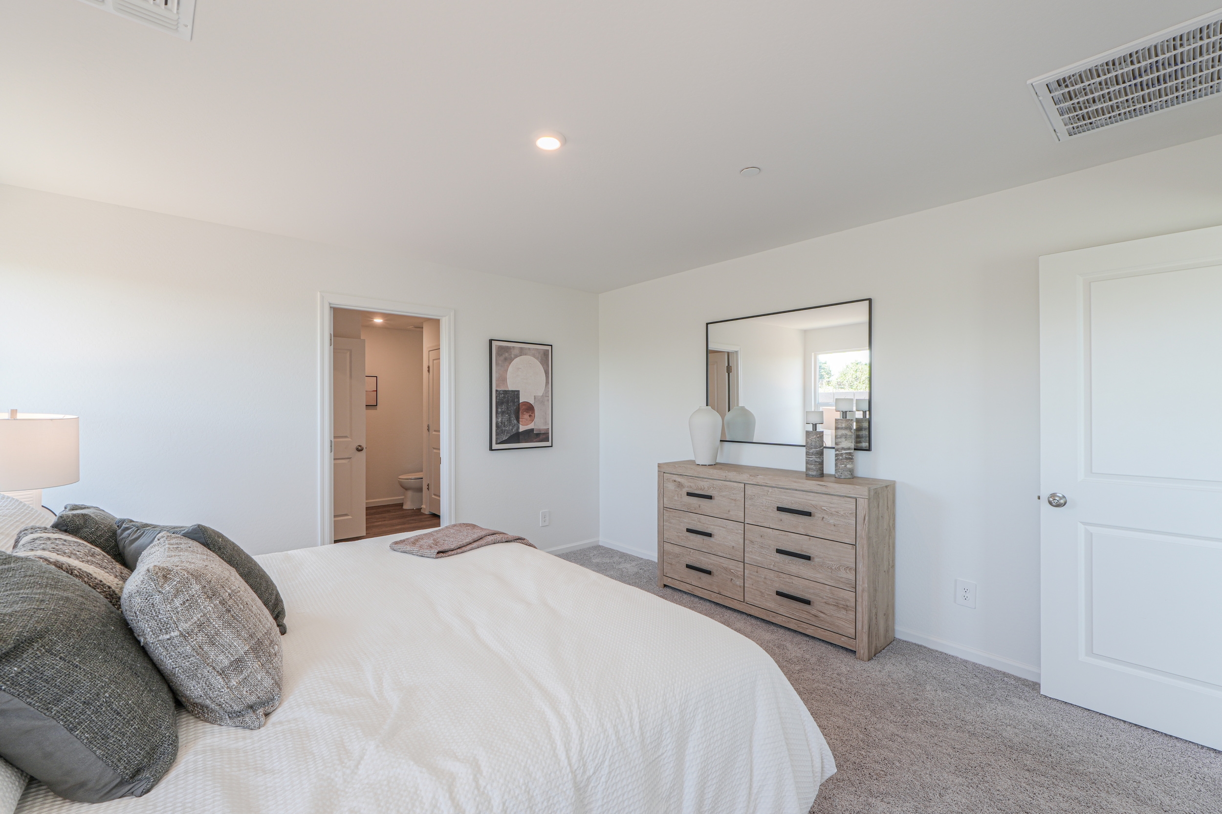 A bedroom with a bed and dresser.