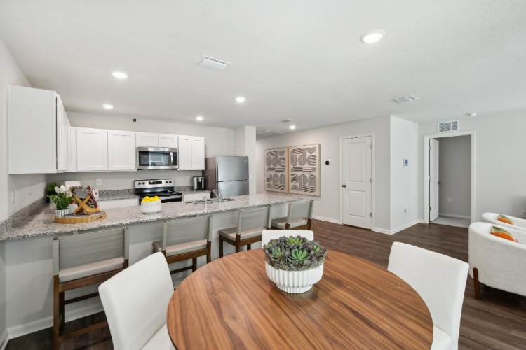 A kitchen with a table and chairs.
